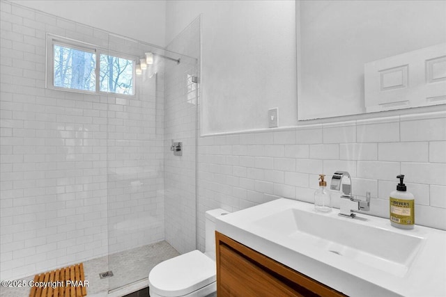 full bath with toilet, a walk in shower, tile walls, and vanity