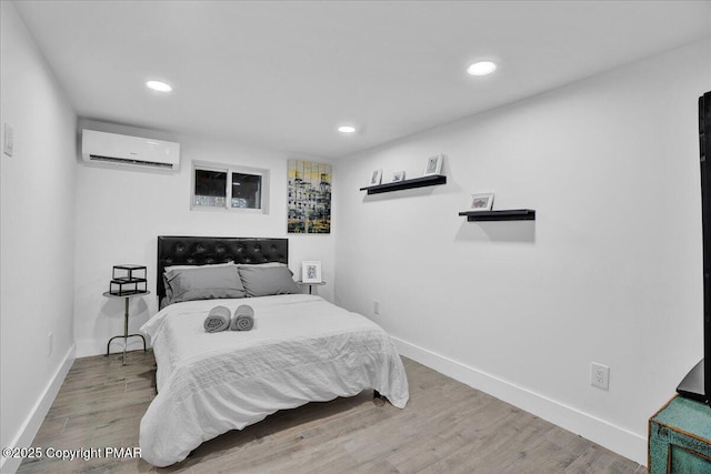 bedroom featuring recessed lighting, a wall unit AC, wood finished floors, and baseboards