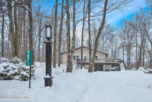 view of snow covered exterior with a wooden deck