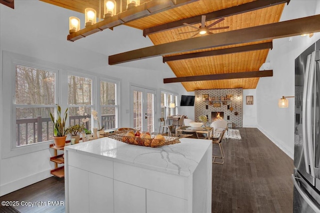 kitchen featuring a fireplace, white cabinets, open floor plan, light stone countertops, and modern cabinets