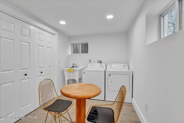 interior space featuring light wood finished floors, separate washer and dryer, and a wealth of natural light