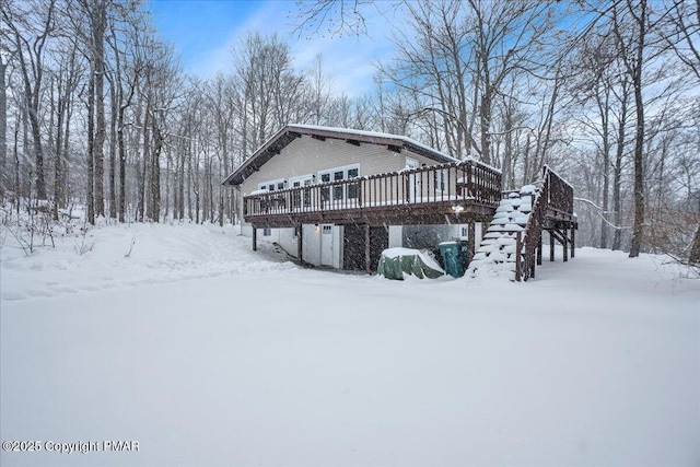 view of snowy exterior featuring a deck