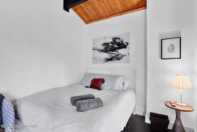 bedroom featuring dark wood finished floors, wood ceiling, and vaulted ceiling with beams