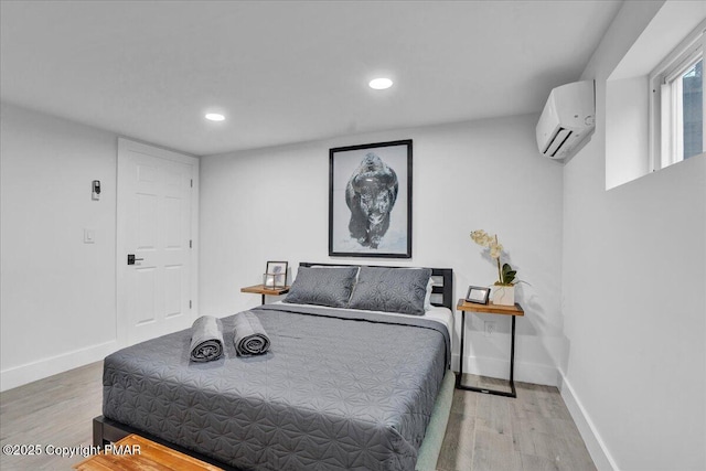 bedroom with recessed lighting, a wall mounted air conditioner, baseboards, and wood finished floors