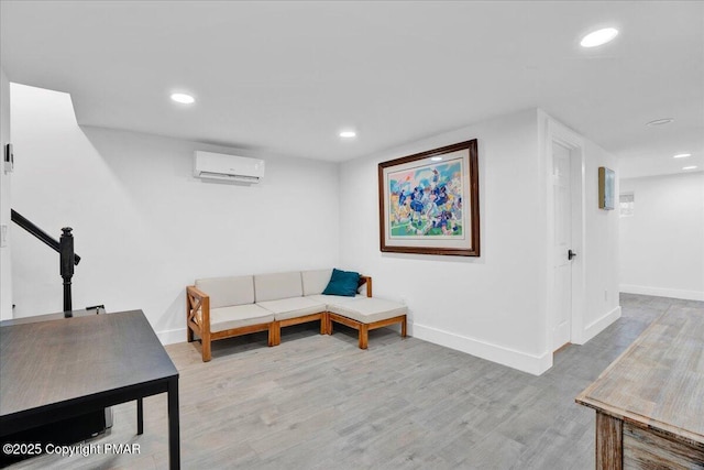 living area featuring recessed lighting, baseboards, light wood finished floors, and a wall mounted AC