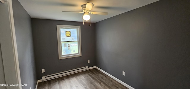 spare room with ceiling fan, a baseboard radiator, wood finished floors, and baseboards