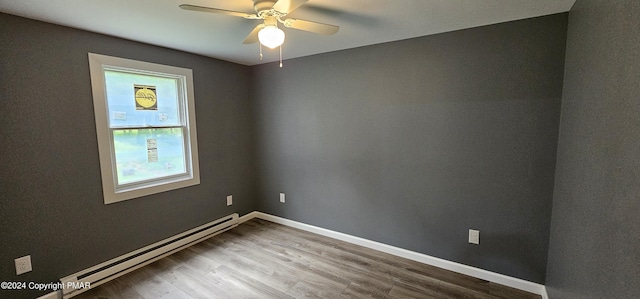 spare room with a ceiling fan, baseboards, baseboard heating, and wood finished floors