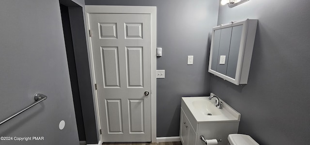 half bathroom featuring vanity and toilet