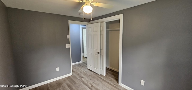 unfurnished bedroom with light wood-style floors, a closet, baseboards, and a ceiling fan