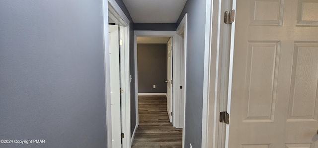 corridor with baseboards and dark wood-style flooring