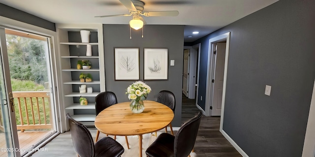 dining space featuring ceiling fan, baseboards, built in features, and wood finished floors