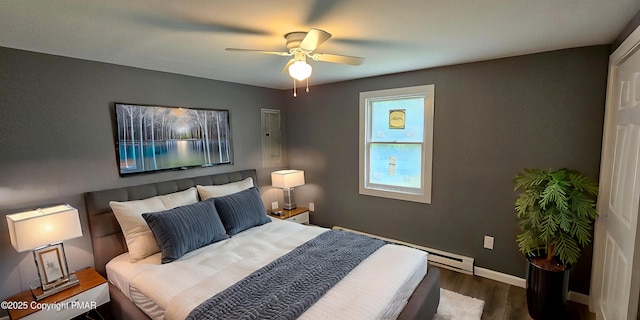 bedroom featuring a ceiling fan, baseboards, baseboard heating, and dark wood-style flooring