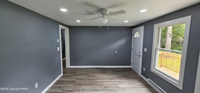 spare room with wood finished floors, baseboards, recessed lighting, ceiling fan, and a baseboard heating unit