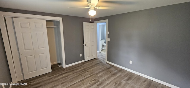 unfurnished bedroom with a closet, ceiling fan, baseboards, and wood finished floors