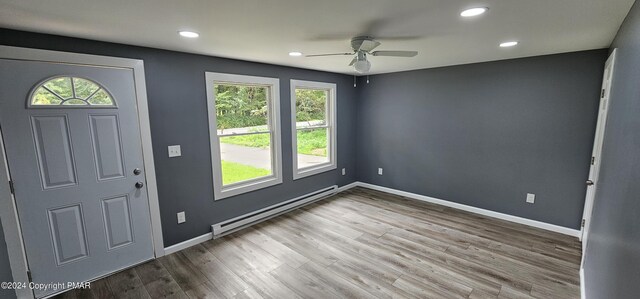 foyer with a baseboard heating unit, wood finished floors, baseboards, and ceiling fan