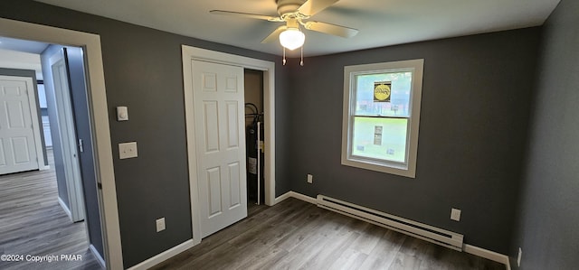 unfurnished bedroom featuring dark wood-type flooring, baseboards, ceiling fan, and baseboard heating