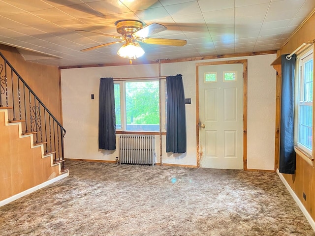 entryway featuring radiator, healthy amount of natural light, carpet flooring, and a ceiling fan
