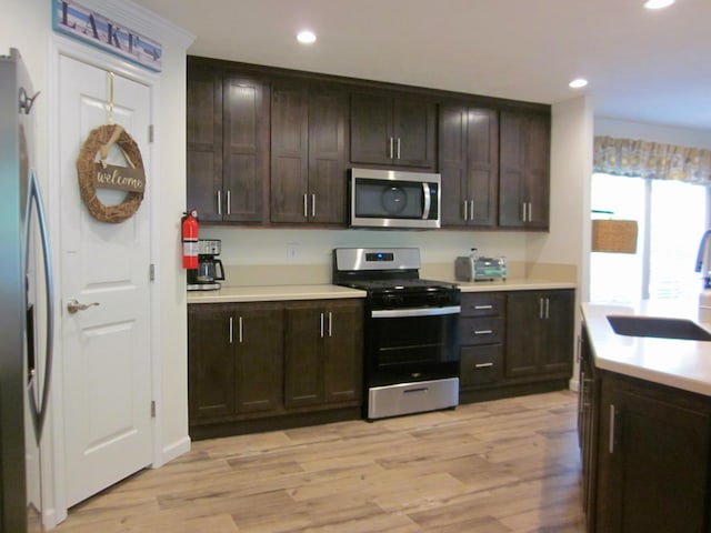 2016 Locust Ridge Rd, Pocono Lake, PA 18347 - kitchen with stainless steel appliances, a sink, dark brown cabinets, light wood-style flooring, and recessed lighting