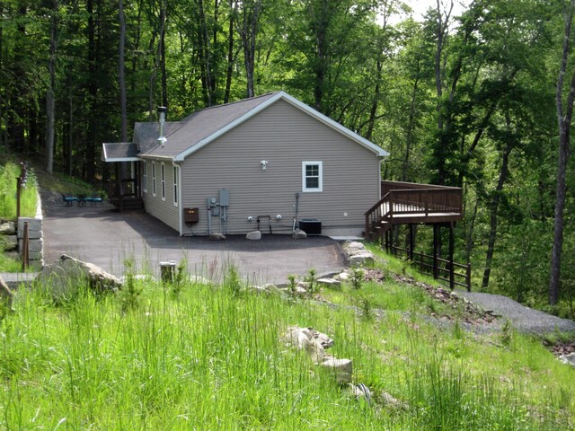 2016 Locust Ridge Rd, Pocono Lake, PA 18347 - rear view of house featuring a wooden deck, a view of trees, and central AC unit