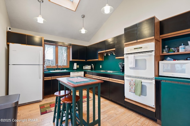 2222 Hillcrest Dr, Pocono Pines, PA 18350 - kitchen with light wood finished floors, white appliances, dark cabinetry, and a sink