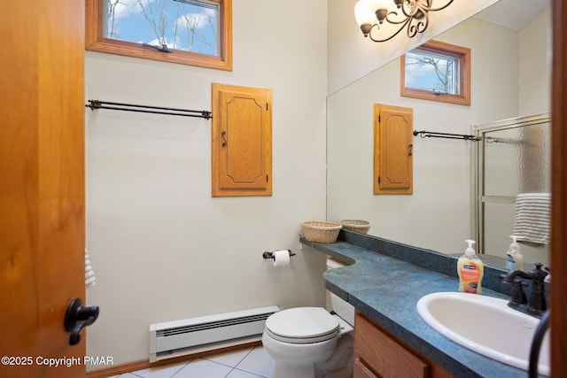 bathroom featuring vanity, toilet, baseboard heating, and tile patterned flooring