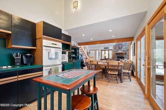 2222 Hillcrest Dr, Pocono Pines, PA 18350 - kitchen with light wood-type flooring, a stone fireplace, recessed lighting, white appliances, and open shelves