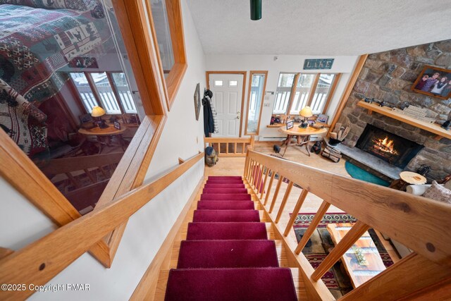 2222 Hillcrest Dr, Pocono Pines, PA 18350 - staircase featuring a fireplace and a textured ceiling