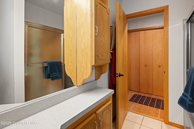 bathroom with vanity, an enclosed shower, and tile patterned flooring