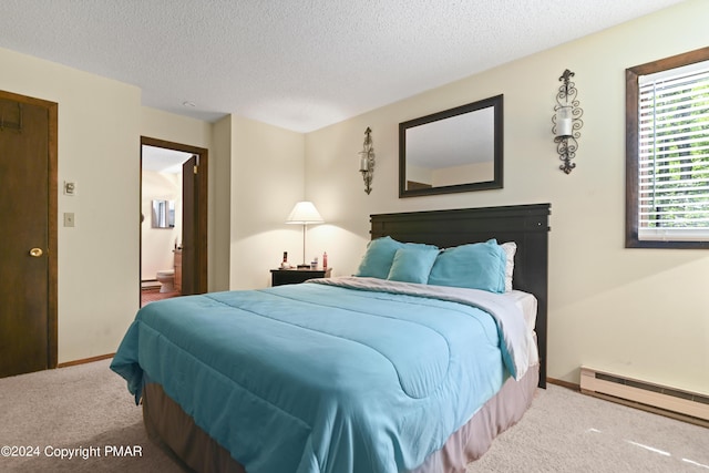 carpeted bedroom featuring ensuite bath, a textured ceiling, baseboards, and a baseboard radiator