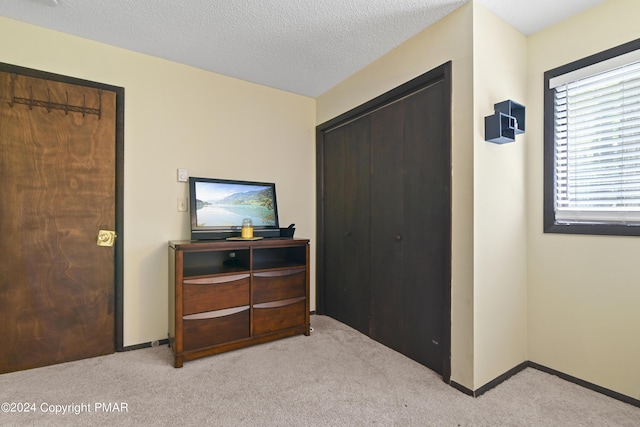 bedroom with baseboards, a textured ceiling, and carpet flooring