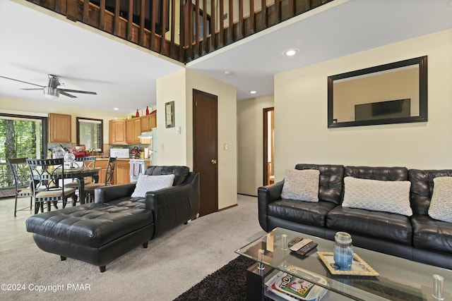 living room with a high ceiling, recessed lighting, a ceiling fan, and light colored carpet