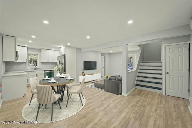 dining room featuring sink and light hardwood / wood-style floors