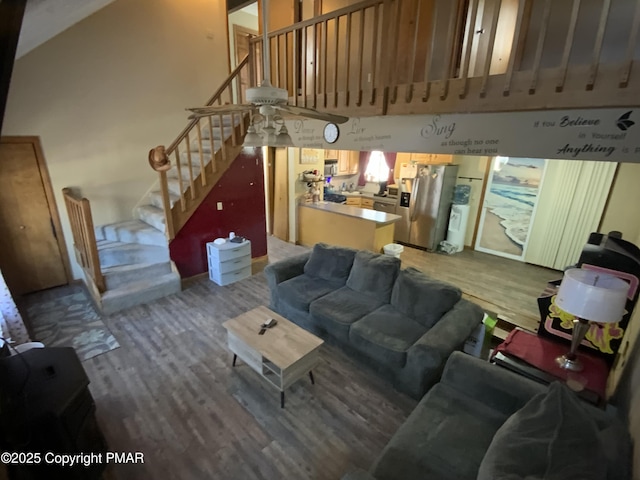 living area featuring stairs, a high ceiling, and wood finished floors