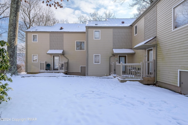 snow covered property with a wooden deck