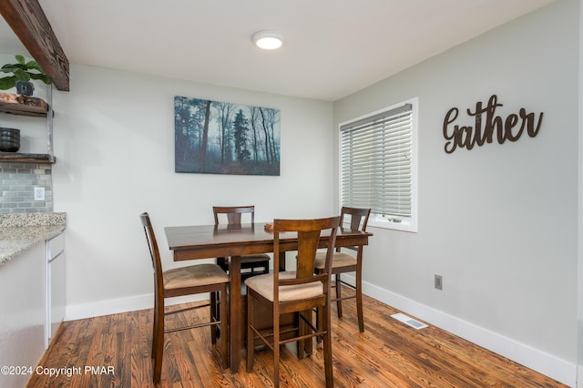 dining space with visible vents, baseboards, and wood finished floors