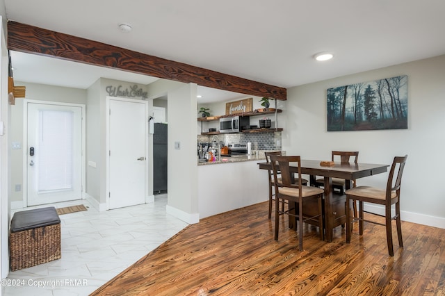 dining area with recessed lighting, wood finished floors, beam ceiling, and baseboards