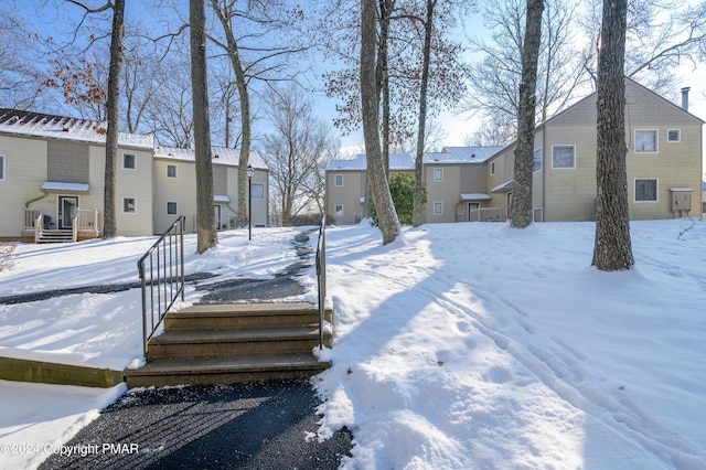 yard covered in snow featuring a residential view