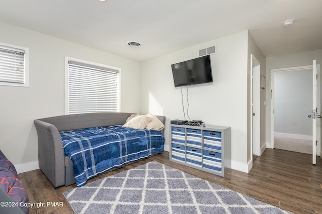 bedroom featuring visible vents, baseboards, and wood finished floors