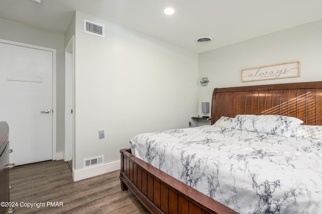 bedroom featuring wood finished floors, visible vents, and baseboards