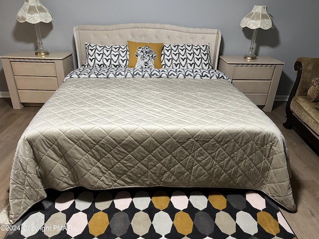 bedroom with baseboards and wood finished floors