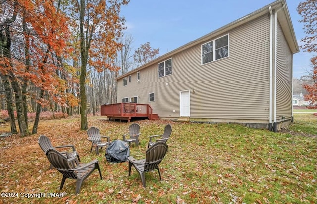 rear view of property featuring a deck and a lawn