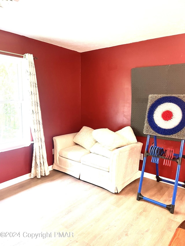 sitting room with a healthy amount of sunlight, baseboards, and wood finished floors