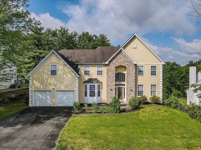 2358 Snapdragon Pt, East Stroudsburg, PA 18301 - traditional home with stucco siding, driveway, stone siding, a front lawn, and a garage