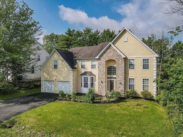 2358 Snapdragon Pt, East Stroudsburg, PA 18301 - traditional-style home featuring stucco siding, stone siding, asphalt driveway, a front yard, and an attached garage