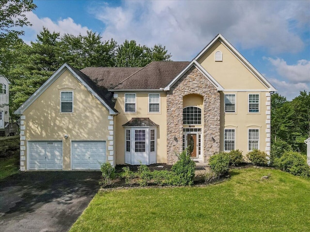 2358 Snapdragon Pt, East Stroudsburg, PA 18301 - traditional-style house featuring stucco siding, stone siding, asphalt driveway, a front lawn, and an attached garage