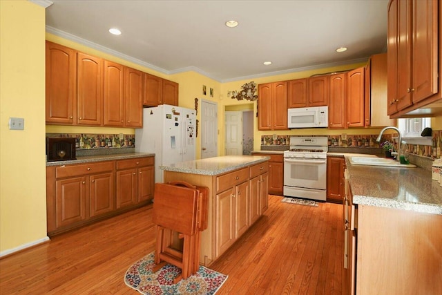 2358 Snapdragon Pt, East Stroudsburg, PA 18301 - kitchen with white appliances, crown molding, light wood-type flooring, light stone counters, and a center island