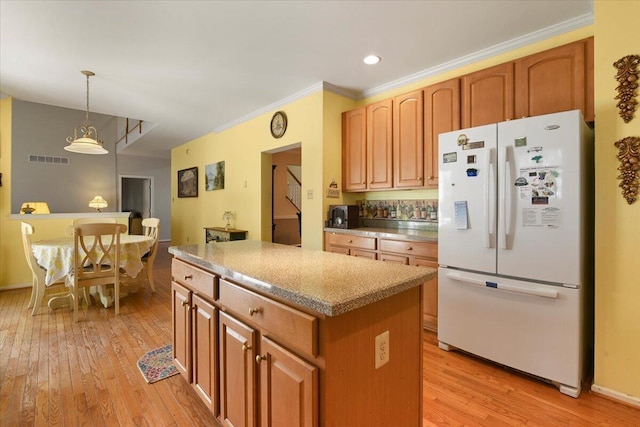 2358 Snapdragon Pt, East Stroudsburg, PA 18301 - kitchen with freestanding refrigerator, a center island, light wood-style flooring, decorative light fixtures, and recessed lighting
