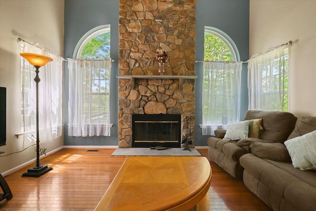 2358 Snapdragon Pt, East Stroudsburg, PA 18301 - living room featuring healthy amount of natural light, hardwood / wood-style flooring, a stone fireplace, and a high ceiling