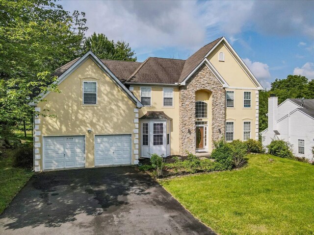 2358 Snapdragon Pt, East Stroudsburg, PA 18301 - view of front of property with asphalt driveway, stucco siding, stone siding, a front lawn, and an attached garage
