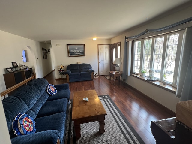 living room with dark wood-type flooring and baseboards